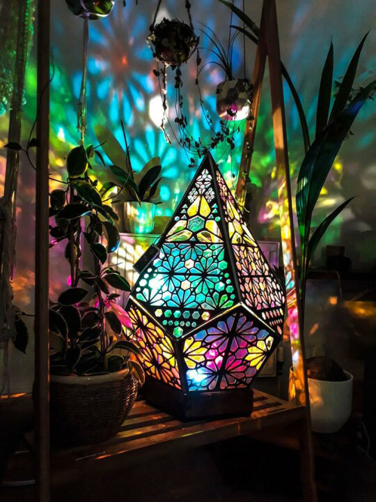 Bohemian diamond-shaped lamp with colorful, projected light illuminating the room.