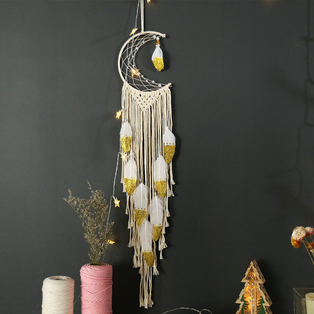 Boho wall hanging semi dream catcher with handwoven cotton and gold-tipped feathers in a crescent moon design.