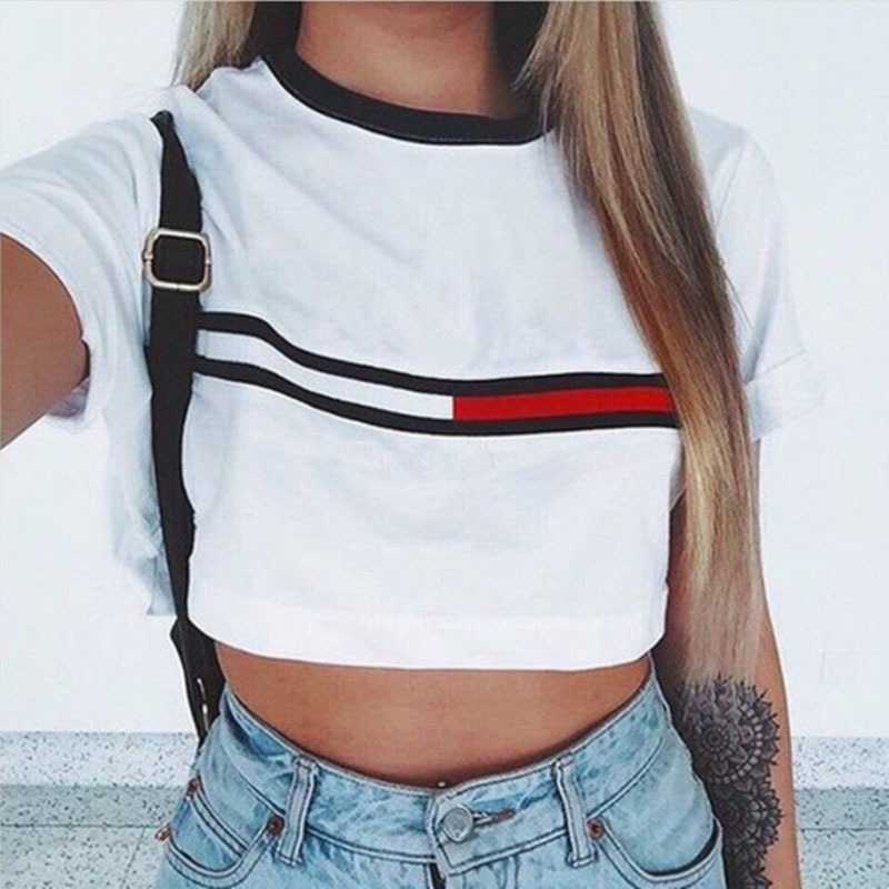 Woman wearing a white cropped t-shirt with black and red stripe design, styled with high-waisted jeans for a casual yet feminine look.