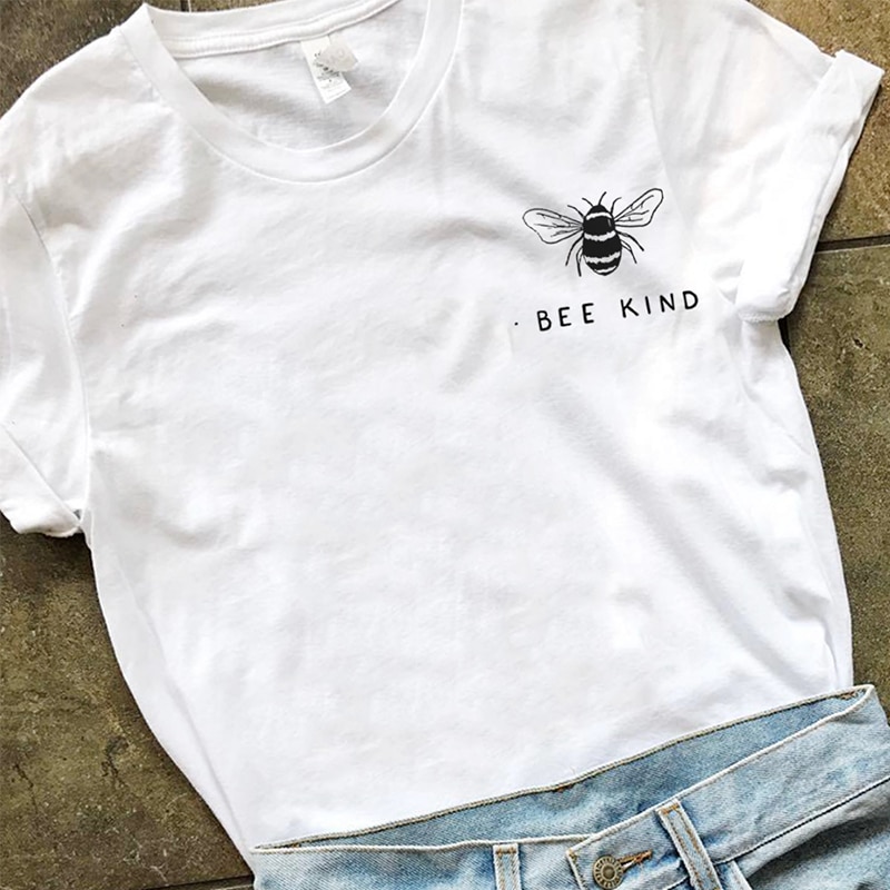 White t-shirt with "Bee Kind" printed alongside a minimalist bee illustration, styled with light blue jeans for a casual, eco-conscious look.