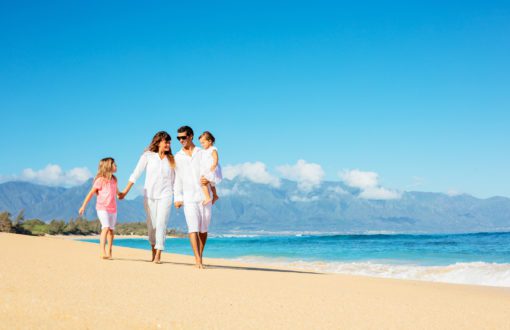 Happy Family plays on a beach in white beach clothes